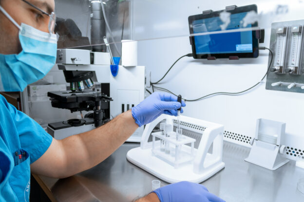 Embryologist adding sperm to egg in laboratory of reproductive clinic